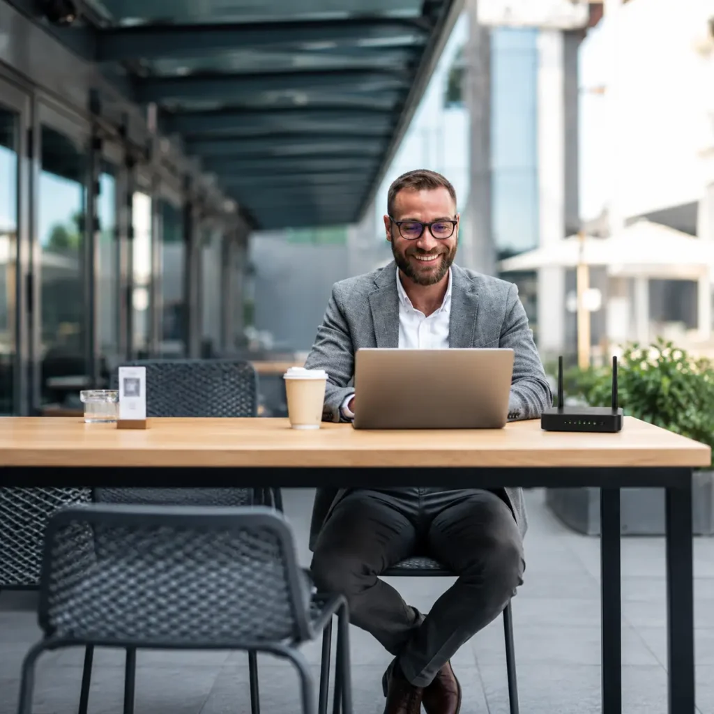 Business professional using a laptop with a router for wireless network connectivity