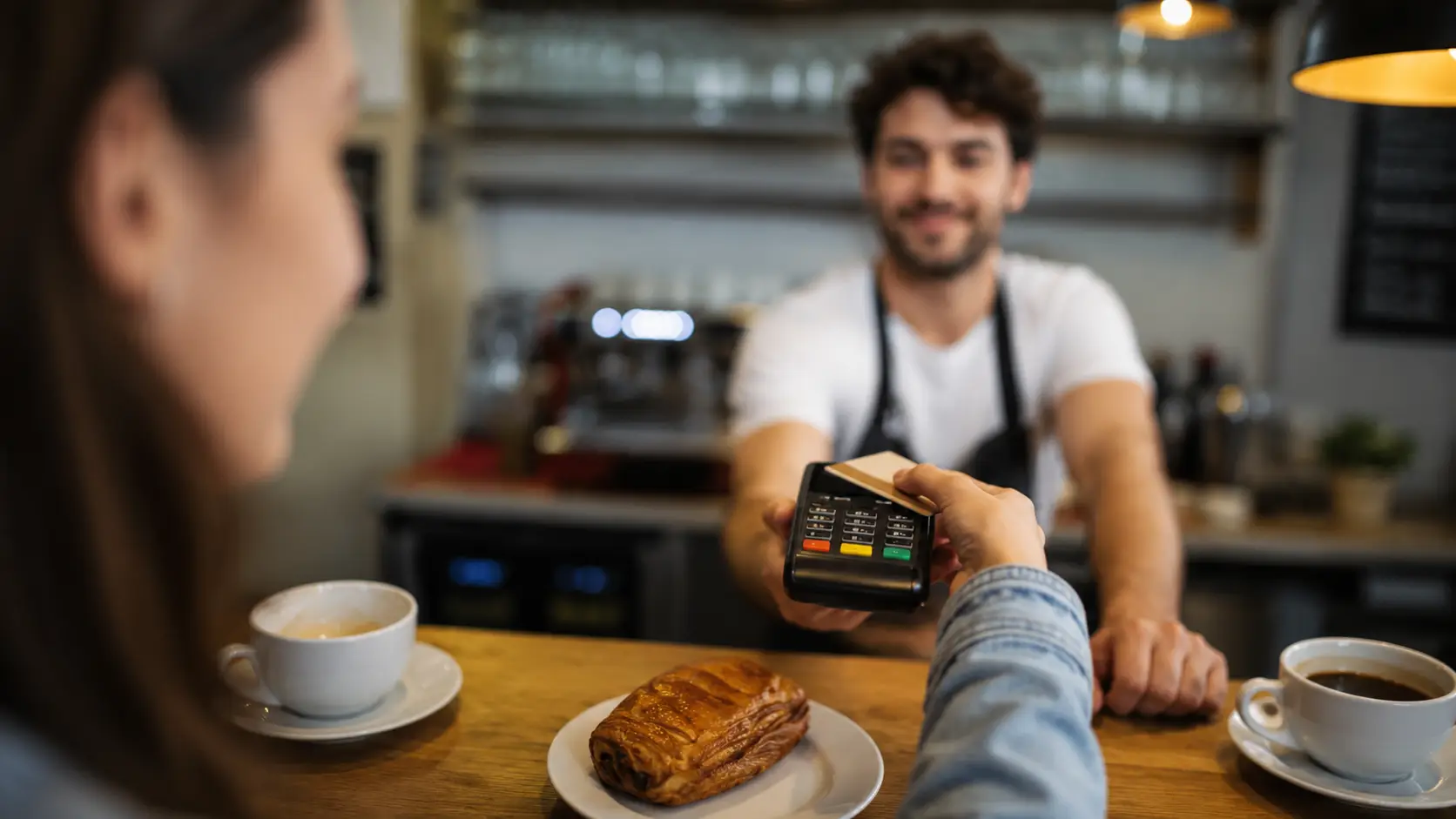 Customer making a card payment with an EPOS terminal in a café
