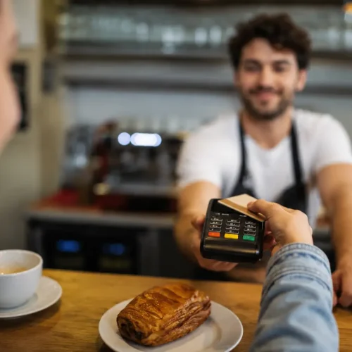 Customer making a card payment with an EPOS terminal in a café